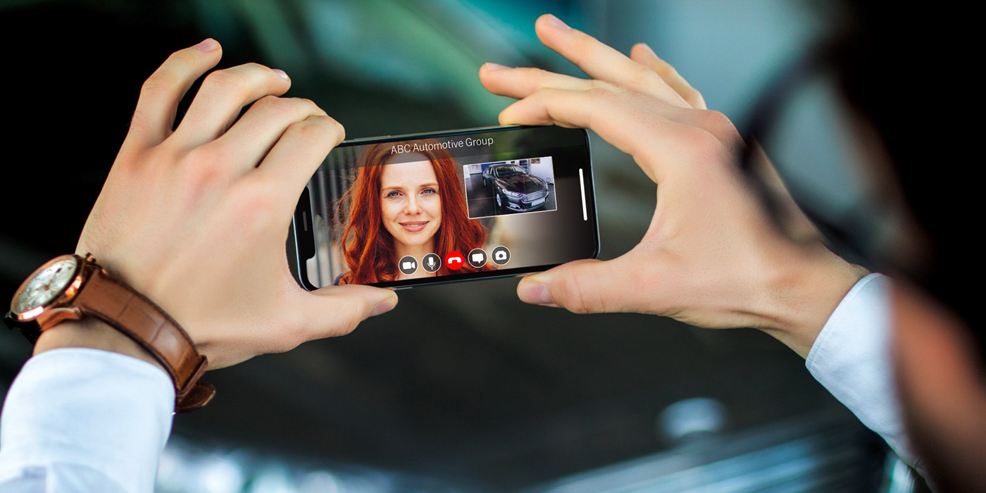 a man holding phone showing car to a female