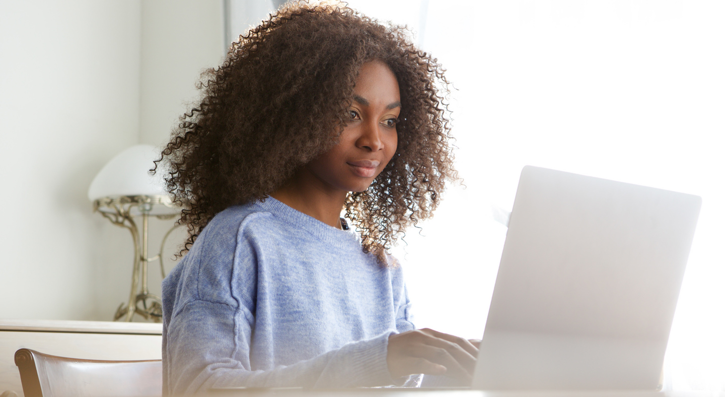 魅力的な若いアフリカ人女性が、家でラテン語を勉強している。 モバイル機器を使う人々