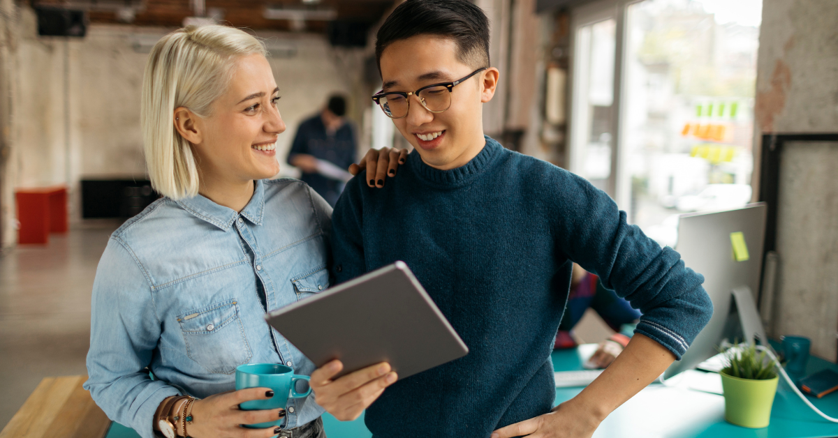 2 employees communicating to each other while holding a tablet