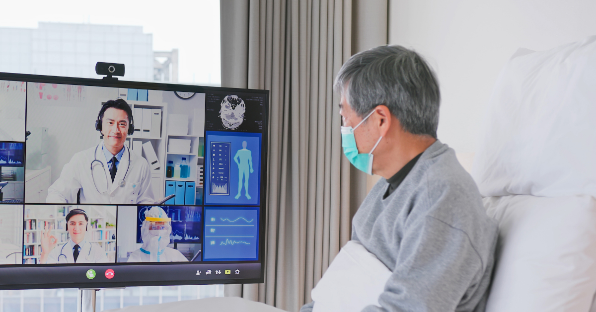 Una experiencia de telemedicina con un anciano sentado en la cama en una videollamada con médicos.