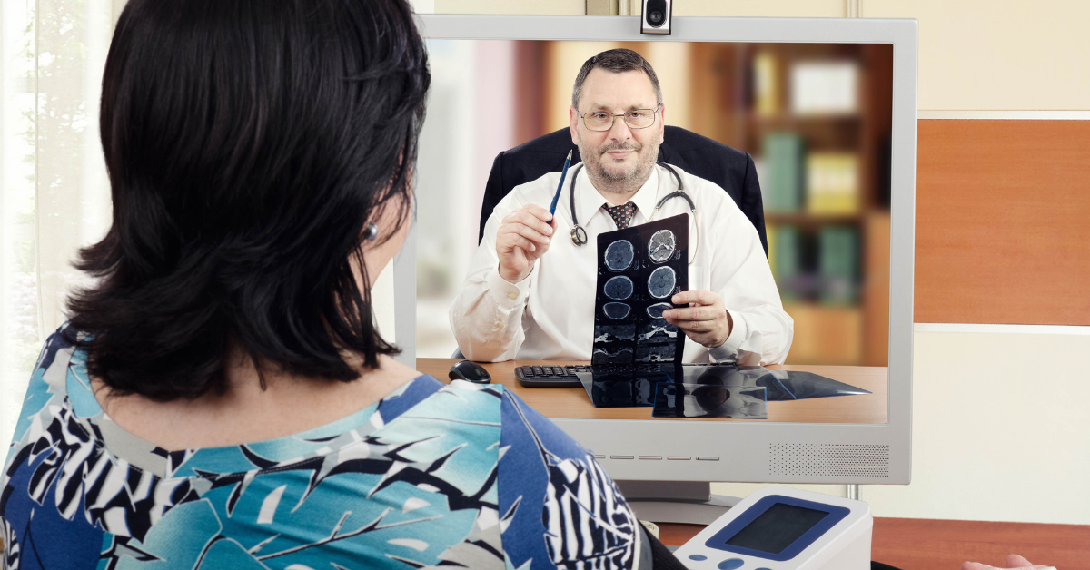 Nurse assisting elderly patient contact her doctor using a remote patient monitoring solution