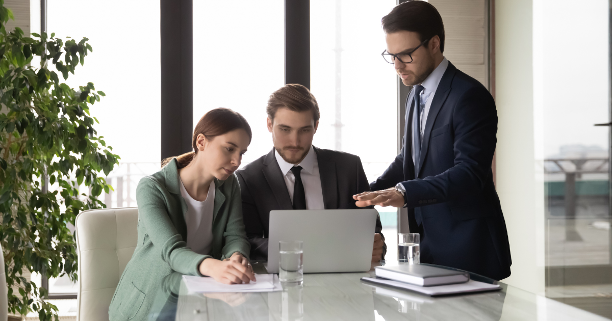 Group of 3 professionals looking at video marketing for banks on a laptop