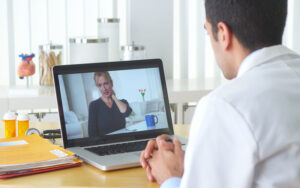 Doctor consutling patient virtually on laptop