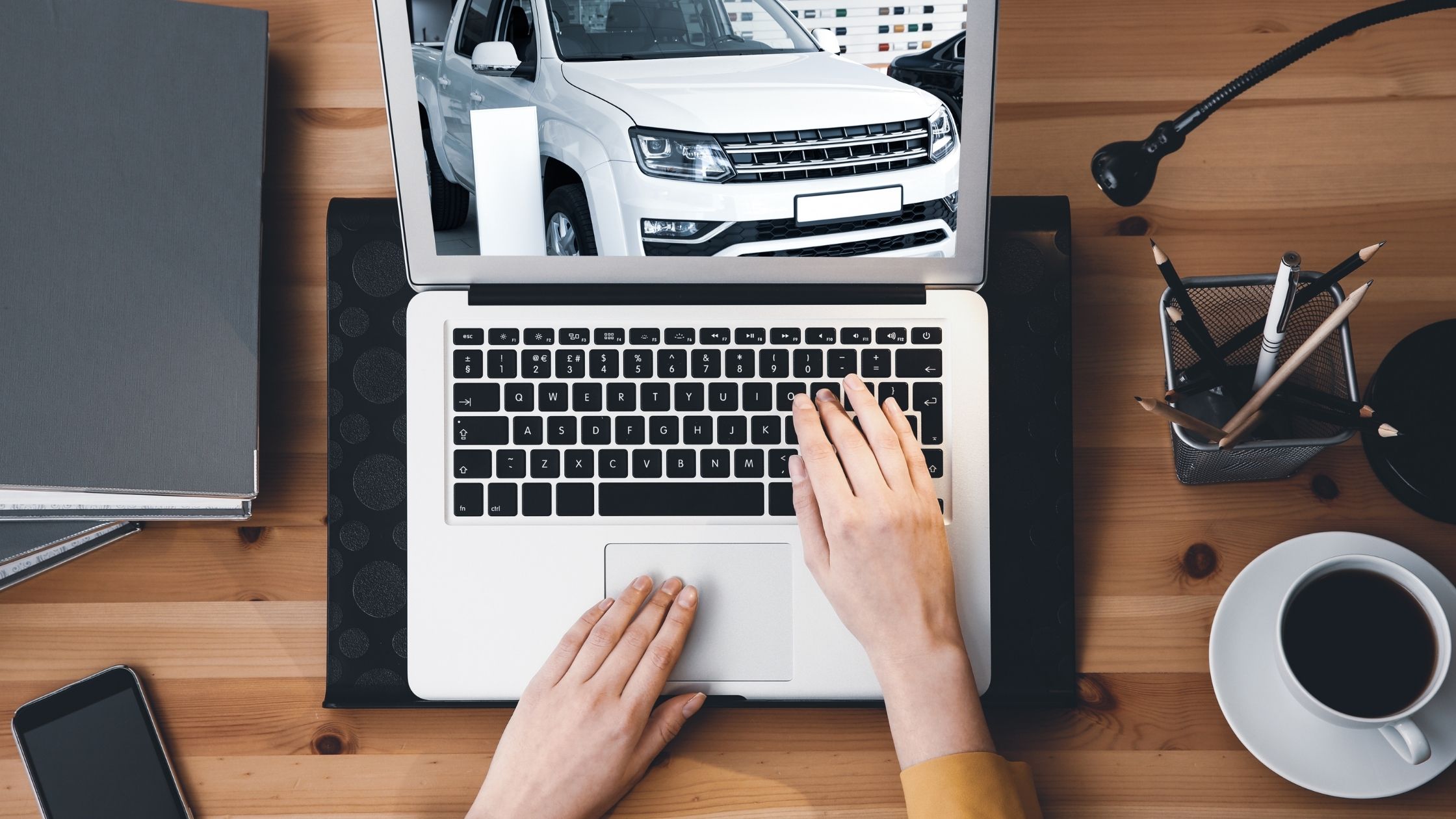 Woman purchasing a car, doing a vehicle tour with her laptop.