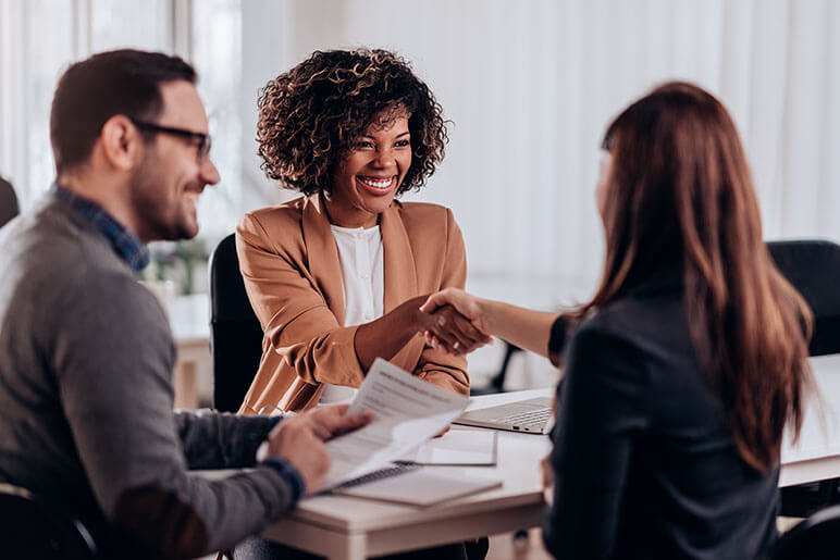 femme assureur serrant la main de clients