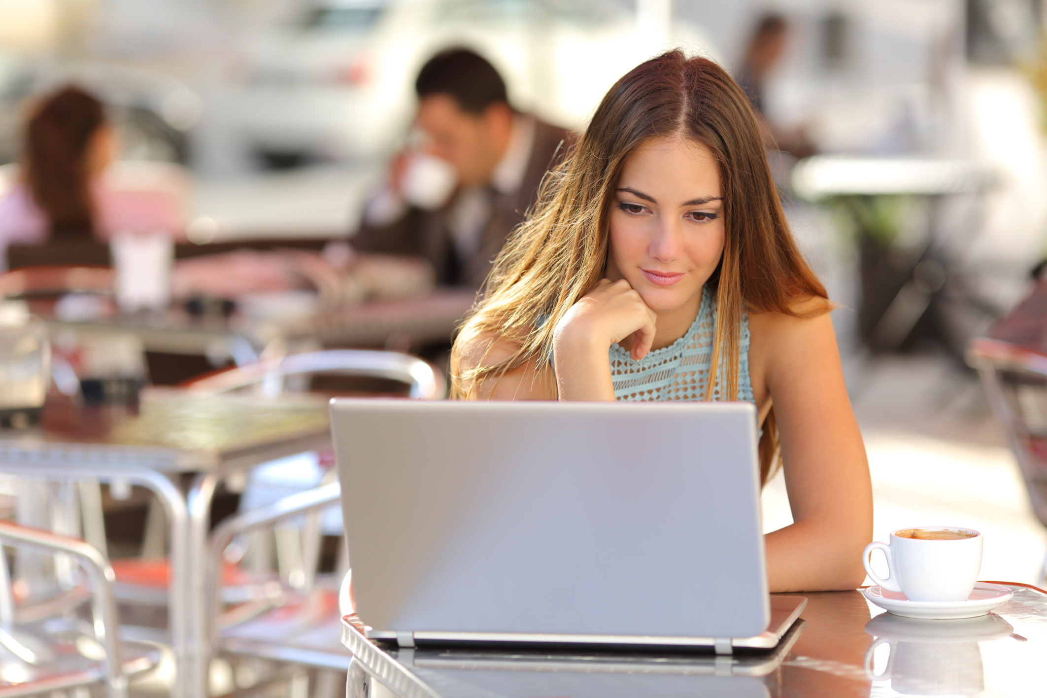 Woman watching video in a laptop in a coffee shop