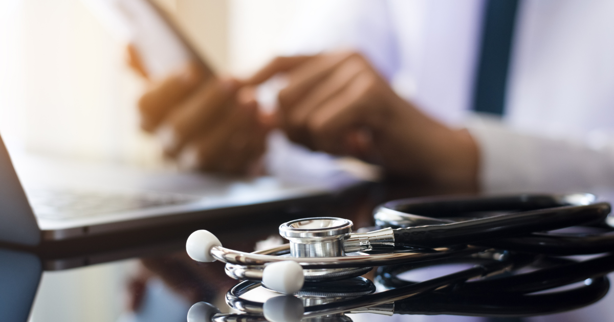 Ein Arzt nutzt die Integration der elektronischen Gesundheitsakte (EHR) über seinen Laptop und sein Telefon.