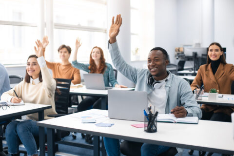 Portrait of smiling diverse people raising hands at seminar Portrait of smiling diverse people raising hands at seminar